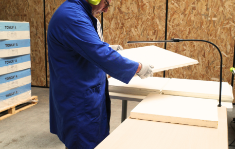 Opérateur triant des dalles de plafond acoustique Eurocoustic dans un atelier de réemploi, avec inspection visuelle et préparation pour réutilisation.