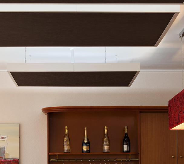 Interior of a modern restaurant featuring acoustic ceiling tiles for improved sound comfort, with warm lighting and contemporary decor.